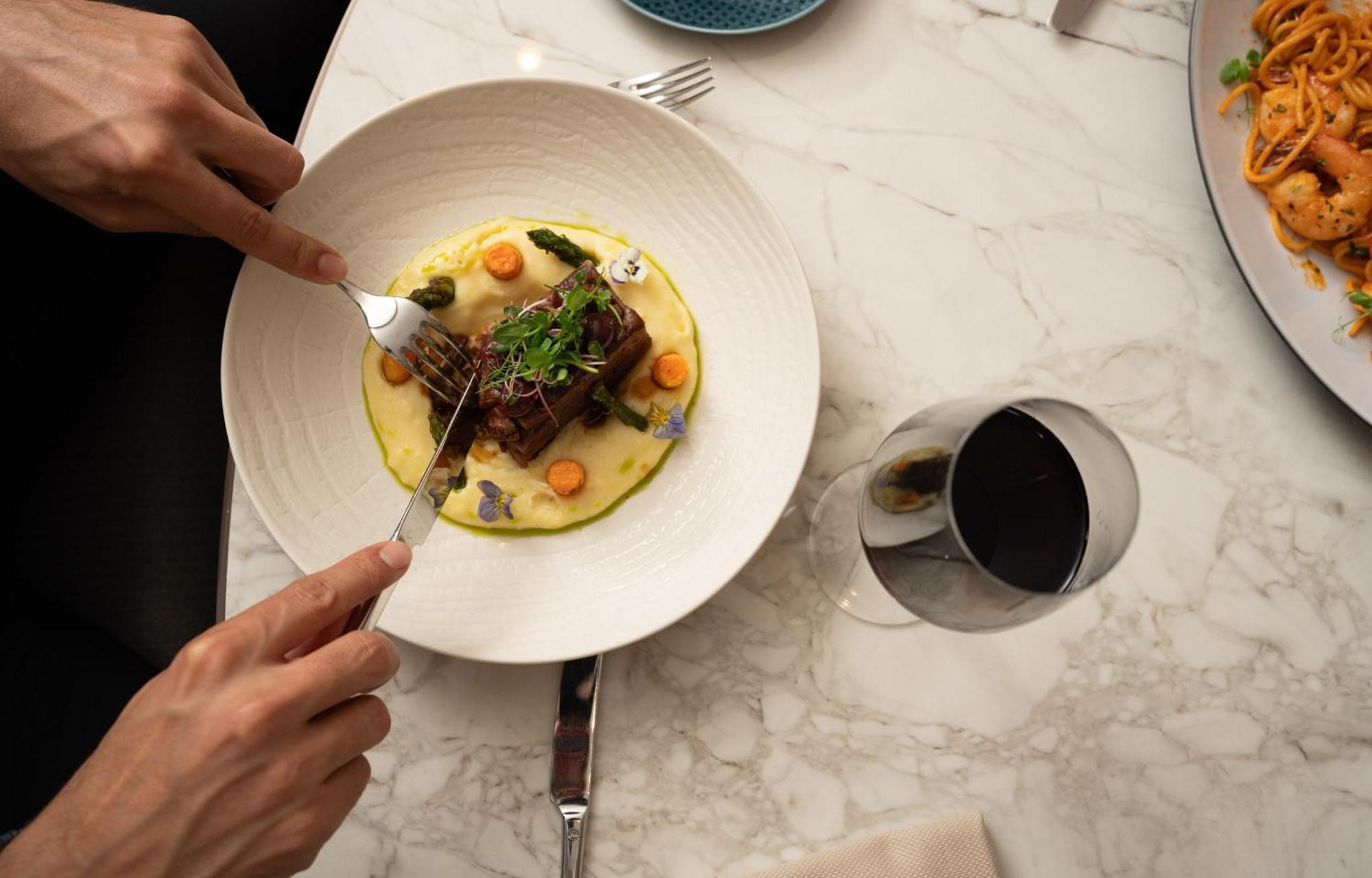 Address Istanbul Hotell Eksteriør bilde A person using a fork to cut into a meal